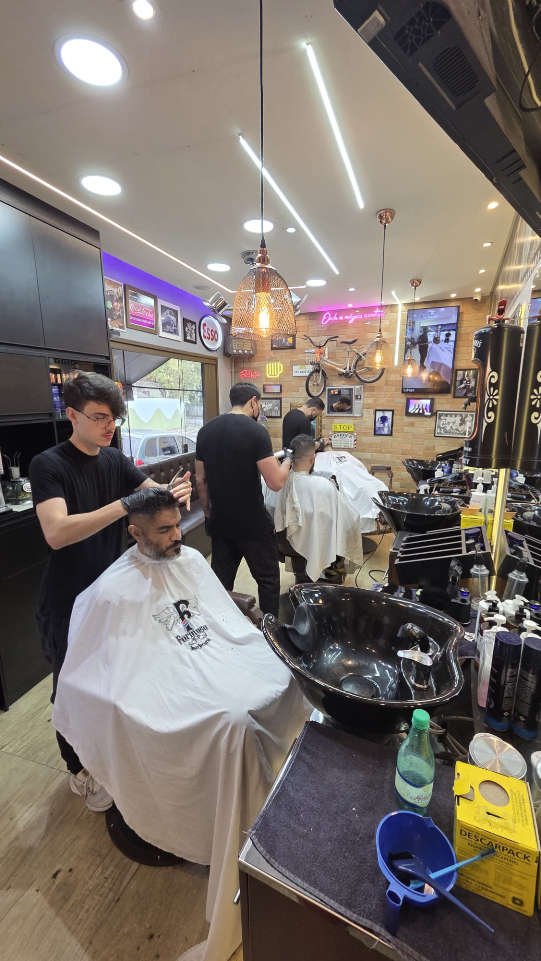 Barbeiro da Barbearia Formoso cortando cabelo de cliente