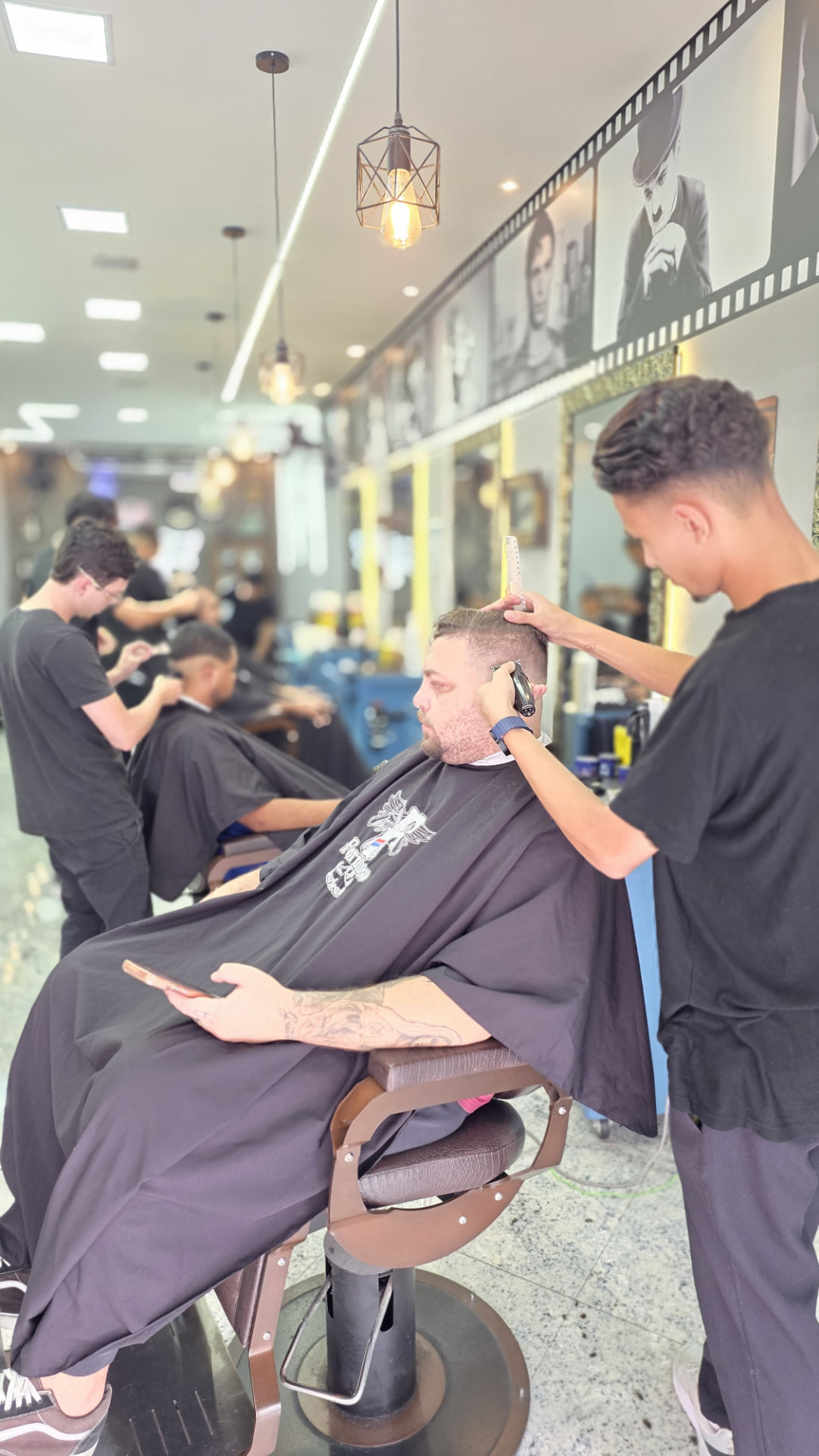 Interior da Barbearia Formoso com barbeiro atendendo cliente